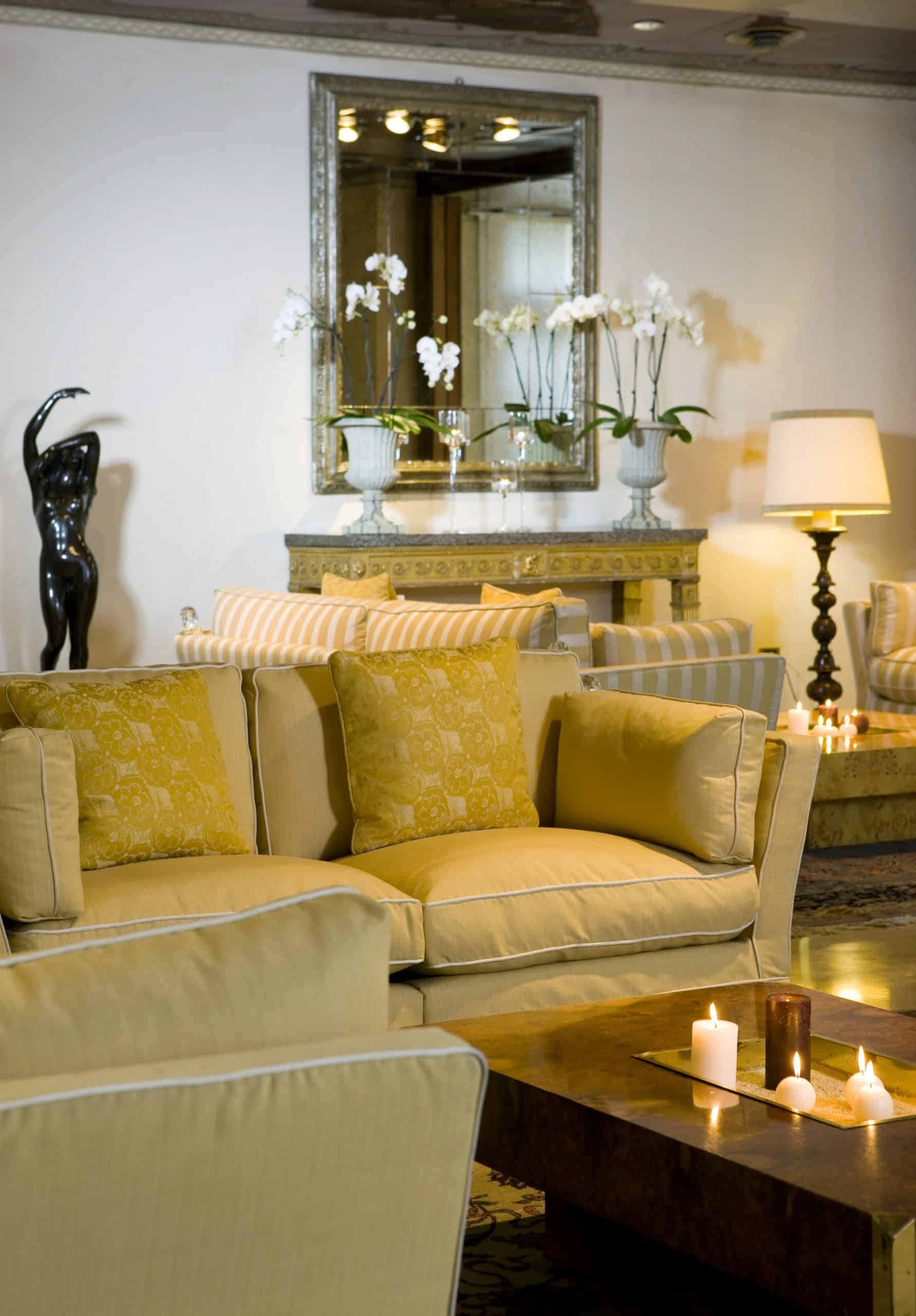 Elegant living room with yellow sofa and lit candles.