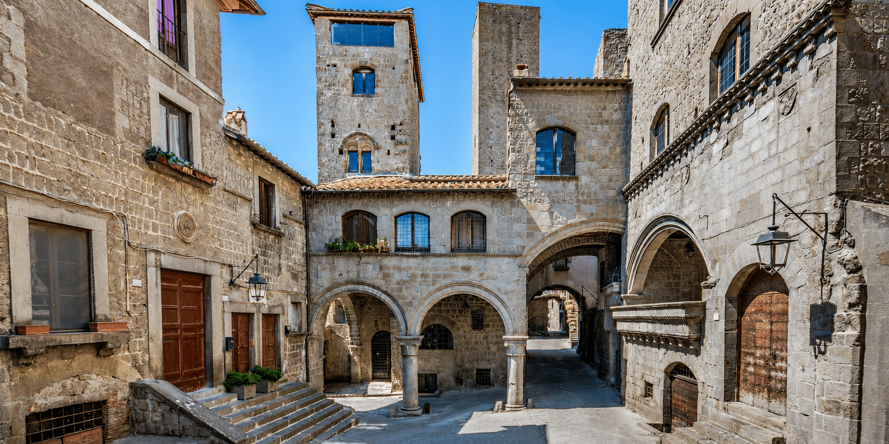 Strada medievale con edifici in pietra e archi.